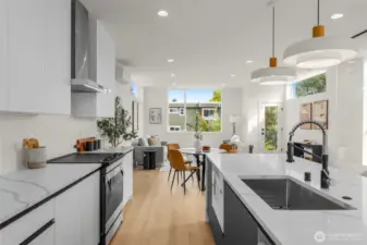 Designer pendant lighting adds an artistic glow above the island, complementing the clean lines and polished finishes.