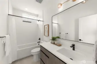 Indulge in a spa-inspired bathroom featuring dual vanities, polished tile, and a frameless glass shower that brings luxury into the everyday.