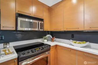 Sleek stainless appliances, stylish cabinetry, and new quartz countertops sparkle in this kitchen.