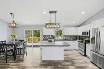 Spacious open floor plan with vaulted ceilings is the ultimate entertainign space!  Think summer BBQ's on your back deck overlooking the private acreage and gatherings in the light bright living area!