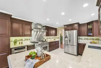 The light & bright quartz countertops are the perfect visual contrast to the rich cabinetry in this spacious kitchen.