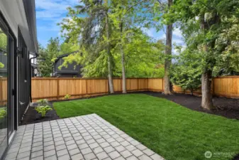Large, flat landscaped and fenced yard with patio