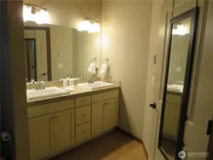 Primary bath has double sinks shown.  Light white cabinetry.