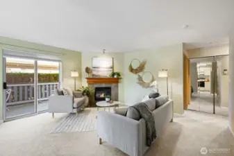Living area with electric fireplace and light filled slider to covered patio