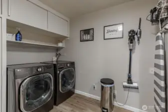 Lower level laundry room with built-ins and shelving for added storage.