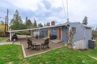 Front exterior with a large patio. This home, ideally located just minutes from the beach, offers the ultimate Pacific Northwest lifestyle.