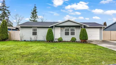Wide front elevation view highlighting the attached garage, fresh exterior, and tidy lawn.