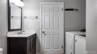 Bathroom and laundry area with updated vanity, stone countertop, and convenient washer and dryer setup. *Washer & Dryer not included*