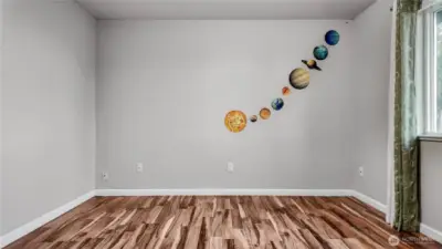 Bedroom with updated flooring and wall space for desk or play area.