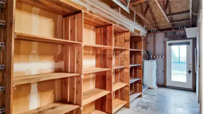 Garage or utility storage area with extensive built-in shelving and exterior door access.