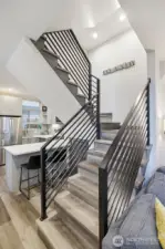 Contemporary staircase with metal railing detail adds architectural interest and connects multiple levels.