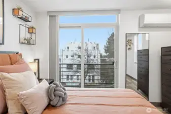 Bright primary suite with large windows, modern finishes, and access to private outdoor space.