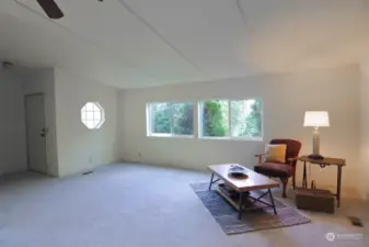 Enter to spacious living room with vaulted ceilings and ceiling fan.