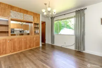 Another view of large dining area with built in cabinet wall for all your special serving dishes.  Doorway to left enters into laundry area.  Beautiful hanging chandelier which remains with home.