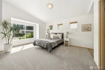Dreamy and spacious primary bedroom with vaulted angled ceiling.
