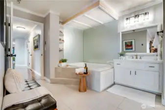 A spa-inspired primary bath offers a separate soaking tub, glass-enclosed shower, and an additional vanity.