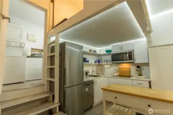 Fully self contained adjacent studio space with washer and dryer to the left and a full bath beyond.  Sleeping loft is above the kitchen.