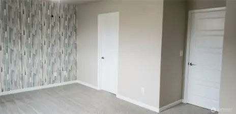 A Picture of the Primary Master Bedroom and door to the Walk In Closet and Entrance Door.