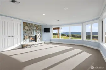Step into the inviting downstairs bonus room,  where comfort meets elegance. This  versatile space features a cozy fireplace,  perfect for creating a warm and welcoming  atmosphere during cooler months. Large  windows frame stunning views, allowing  natural light to fill the room and connect you  with the beauty of the outdoors.