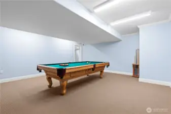 A classic pool table serves as the focal point,  offering endless hours of fun and friendly  competition. The spacious layout ensures  ample room for play and socializing,  creating a perfect setting for gatherings with  family and friends.