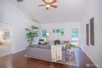 Living room with 2 doors to the back deck and a gas stove