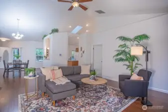 Living room open to the dining room and kitchen beyond.  Primary bedroom on the right.