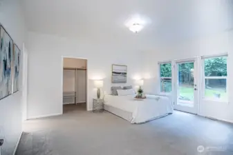 Primary bedroom 1 with door to back deck and lots of natural light.