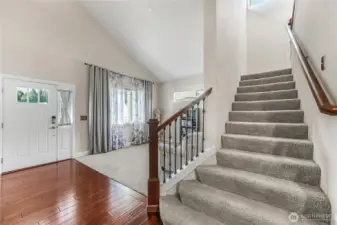 Entry hall and living room with vaulted ceiling.