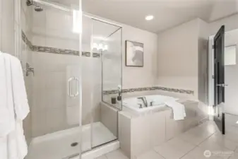 Luxurious tiled primary with separate shower and soaking tub.
