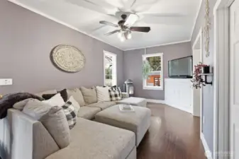 Living room has quant fireplace & ceiling fan to distribute air.
