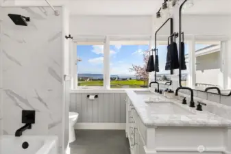 Primary residence main bath has double-sink vanity, tub and shower and amazing Sound and territorial views.