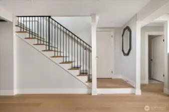 Primary residence stairs to the lower level showing entrance to the half bath at right.