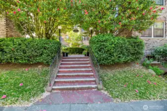Front of building leading to entry through lush courtyard.