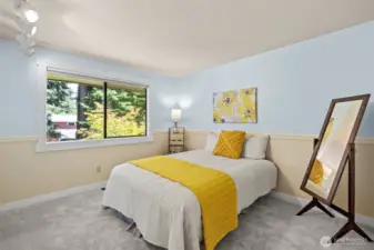 Main-floor second bedroom combines space and warmth, ideal for guests, office, or flex use.