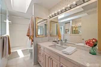 The full main-floor bath impresses with spacious design and a bright skylight.