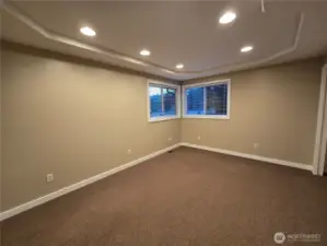 Spacious bedroom with coffered ceiling and recessed lighting.