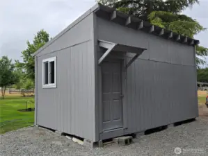 12 x 20 outbuilding with power, built in cabinets and shelves.