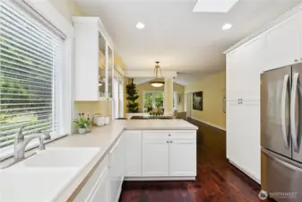 Featuring a double sink and a sleek, newer stainless steel refrigerator, this kitchen blends everyday functionality with modern appeal.