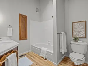 Back inside and just down the hall is the conveniently located bathroom. Tall ceilings and a skylight make the space open and airy feeling.