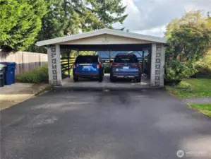 Carport with two full sized SUVs and room left over.