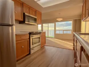 Spacious galley kitchen with a new refrigerator and microwave.