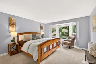 Spacious primary bedroom with a bay window, calming natural light, and room for a sitting area or workspace. It is an easy fit for a king size bed and additional pieces without feeling crowded.