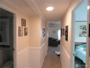 Hallway to living room, second bedroom on the right and bathroom on the left