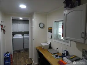 The view of the utility room and workspace from the kitchen.