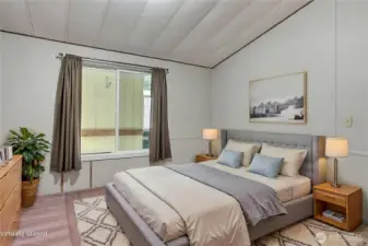 Primary bedroom view, ample in space and the cathedral ceilings continue throughout the length of the home. Sellers put in this large window to add extra light and ease of exit in case of fire or emergency. ***Virtually Staged***