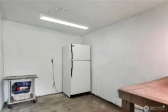 View of inside the storage shed, beer fridge works great and can stay, workbench as well.