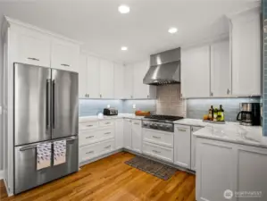 Quartz countertops crowns the white cabinetry.