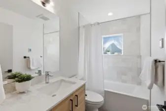 The full bathroom on the main level offers sleek finishes and a deep tub.