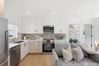 Stainless appliances flank custom cabinets with a warm color palette. Notice the deep sink.