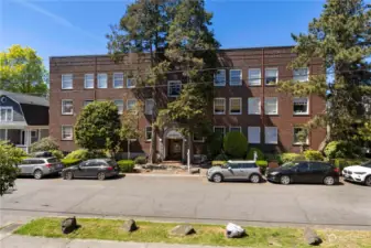View from street of this large condo building that is walking distance to everything with easy link light rail access not far from your home